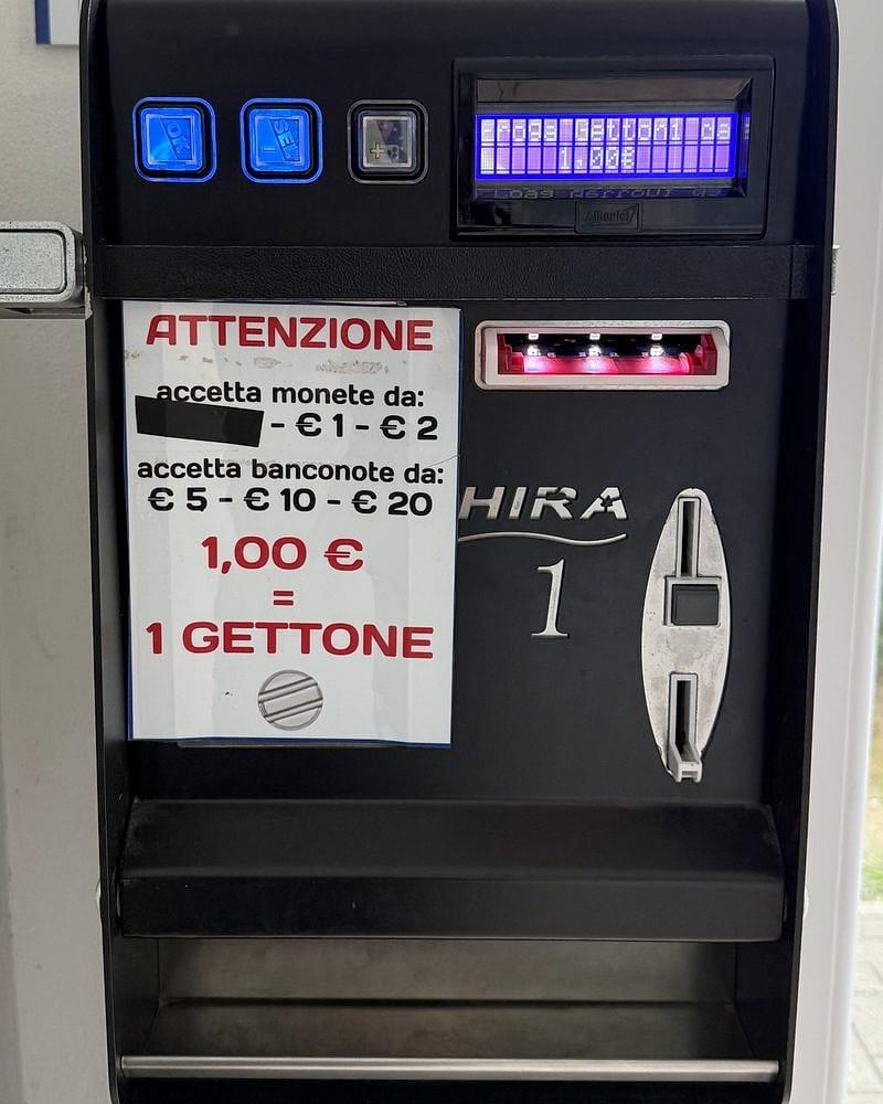 La scambiatrice dei gettoni con il cartello: accetta monete da 1 e 2 € e banconote da 5, 10 e 20 €, 1 € = 1 gettone